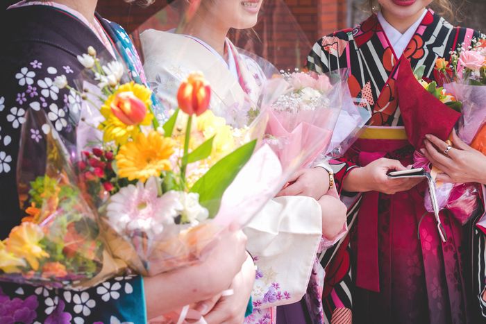卒業祝いの花をもらう学生